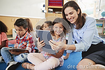 Teacher and girl in elementary class using tablet computers Stock Photo