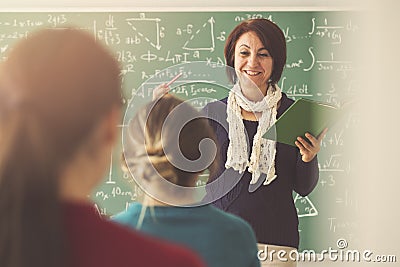 Teacher giving lesson to students in classroom Stock Photo