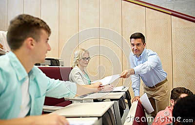 Teacher giving tests to students at lecture Stock Photo