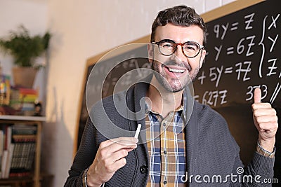 Teacher giving a thumbs up in classroom Stock Photo