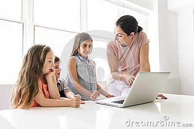 Teacher with a group of school children with laptop on the front Stock Photo