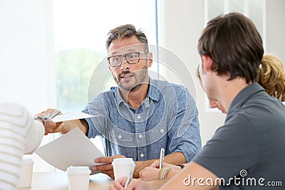 Teacher handing copies to students Stock Photo