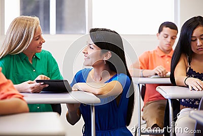 Teacher Helping Female High School Student In Classroom Stock Photo