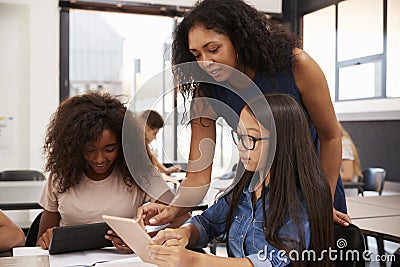 Teacher helping high school students with technology Stock Photo