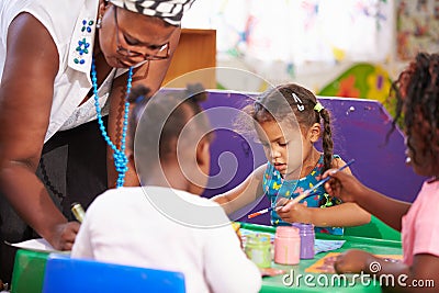 Teacher helping kids in a preschool class, close up Stock Photo