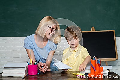 Teacher helping kids with their homework in classroom at school. Preschooler. Home schooling or private school Stock Photo