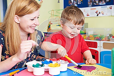 Teacher Helping Preschool Child In Art Class Stock Photo