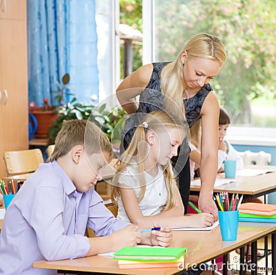 Teacher helping pupil explains how to solve the task Stock Photo