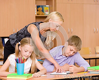 Teacher helping pupil explains how to solve the task Stock Photo