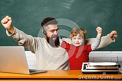 Teacher helping pupils studying on desks in classroom. Preschool pupil. Young or adult. Teacher and kid. Chalkboard copy Stock Photo