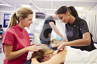 Teacher Helping Student Training To Become Masseuse Stock Photo