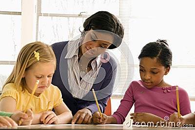 Teacher Helping Students With Schoolwork Stock Photo