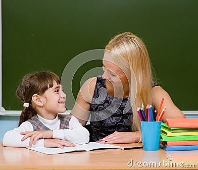 Teacher helping young girl with writing lesson Stock Photo