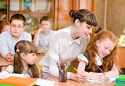 Teacher helps the student with schoolwork in classroom Stock Photo