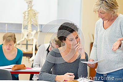 Teacher holding paper and questioning student in anatomy class Stock Photo