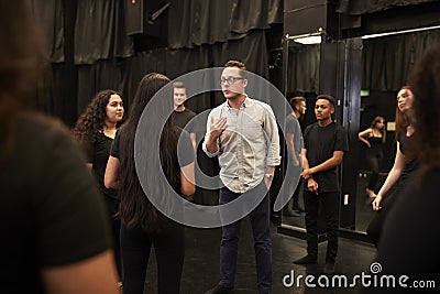 Teacher With Male And Female Drama Students At Performing Arts School In Studio Improvisation Class Stock Photo