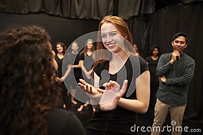 Teacher With Male And Female Drama Students At Performing Arts School In Studio Improvisation Class Stock Photo