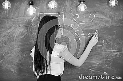 Teacher of mathematics writing on chalkboard, rear view. teacher concept. Lady teacher in glasses explaining Stock Photo