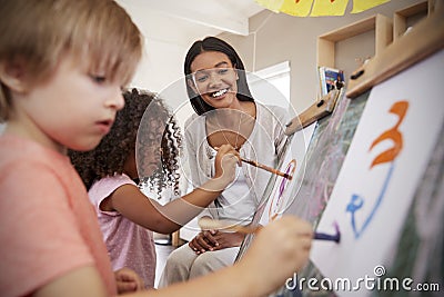 Teacher At Montessori School Helping Children in Art Class Stock Photo