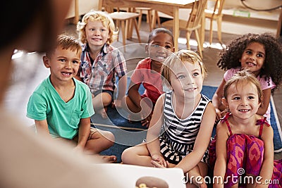 Teacher At Montessori School Reading To Children At Story Time Stock Photo