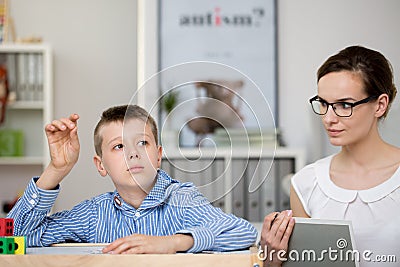 Teacher with notebook observes boy Stock Photo