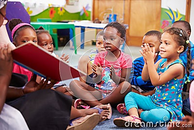 Teacher reading a book with a class of preschool children Stock Photo