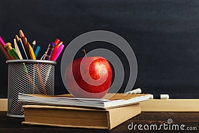 Teacher`s desk with writing materials, a book and an apple, a blank for text or a background for a school theme. Copy space Stock Photo
