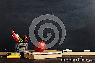 Teacher`s desk with writing materials, a book and an apple, a blank for text or a background for a school theme. Copy space Stock Photo