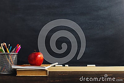 Teacher`s desk with writing materials, a book and an apple, a blank for text or a background for a school theme. Copy space Stock Photo