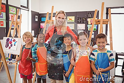 Teacher and schoolkid standing together in drawing class Stock Photo