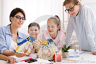 Teacher showing modern robot to children in classroom Stock Photo