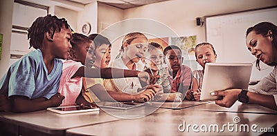 Teacher showing tablet computer to students Stock Photo