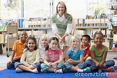 Teacher sitting with children in library Stock Photo
