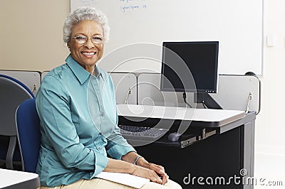 Teacher Sitting In Classroom Stock Photo