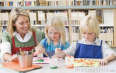 Teacher sitting with students in art class Stock Photo