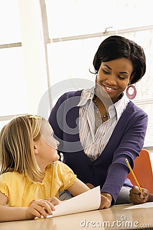 Teacher Smiling and Helping Student Stock Photo