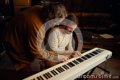 Teacher and student playing synthesizer during lesson Stock Photo