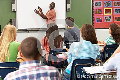 Teacher Using Interactive Whiteboard During Lesson Stock Photo
