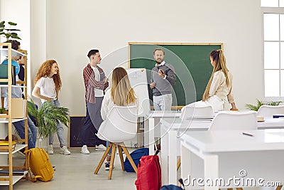 Teacher with whiteboard conducts lesson for students, explaining educational material to them. Stock Photo