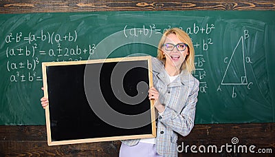 Teacher woman hold blackboard blank advertisement copy space. School information for incoming students. Teacher show Stock Photo