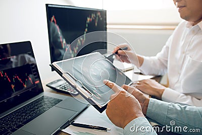 Team of agent trading business people pointing graph and analysis stock market on computer screen in office Stock Photo