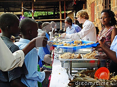 Team aid relief volunteers workers feeding hungry children Africa Editorial Stock Photo