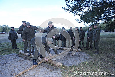 Team-building exercise: soldiers overcome an obstacle courses balancing on logs. Novo-Petrivtsi military base, Ukraine Editorial Stock Photo