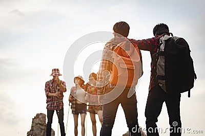 Team of climbers man and woman hiker hiking mountain climbing success stand at the cliff with backpacks on mountain top over. Stock Photo