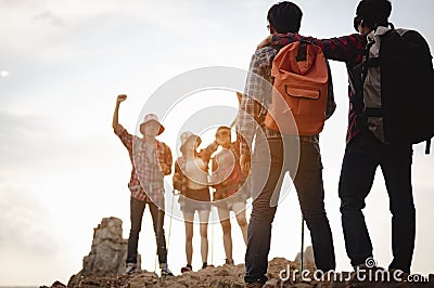 Team of climbers man and woman hiker hiking mountain climbing success stand at the cliff with backpacks on mountain top over . Stock Photo