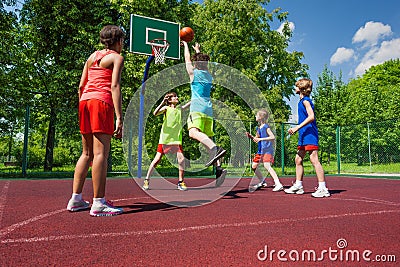 Team in colorful uniforms playing basketball game Stock Photo