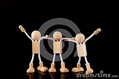 Team concept, Wooden Stick Figures team isolated on black background. Stock Photo
