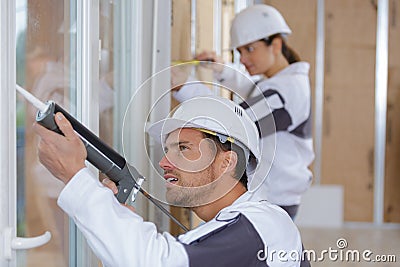 Team construction workers installing window in house Stock Photo