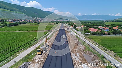 Team of construction workers laying tarmac on road construction site, leveling asphalt gravel Stock Photo