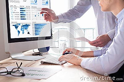 Team discussing business analytics or intelligence dashboard on computer screen Stock Photo
